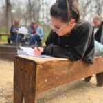 A woman writing in her journal during her Warriors’ Ascent cohort experience